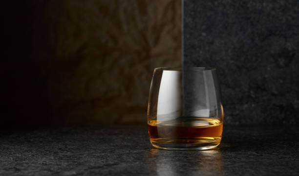 istock Glass of whiskey on a black table. 2180689316