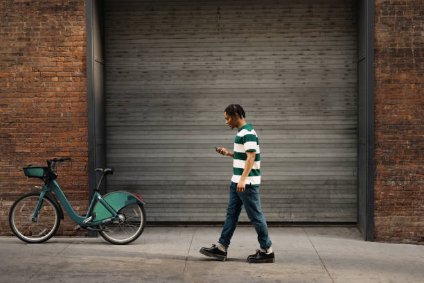 istock Happy black man using mobile phone on the move at the street. 2180690833