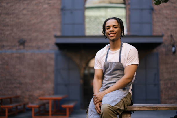 istock Happy black waiter relaxing on a table at the street. 2180692036