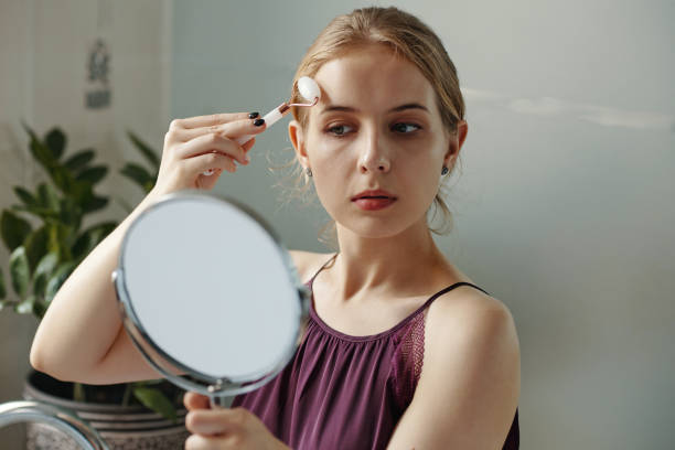 istock Young Woman Applying Makeup in Modern Interior 2180694255