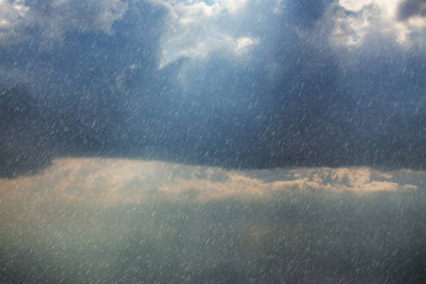 Sunlight Piercing Through Rain Clouds, Illuminating the Sky with a Soft Glow Amid the Gloom stock photo