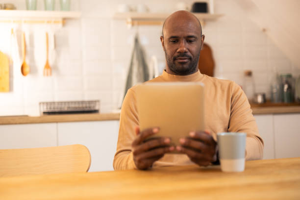istock Latin American man relaxing at home and using tablet 2180701575