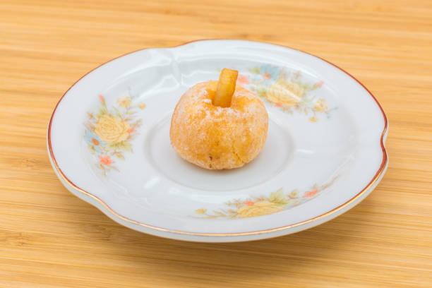 Plate with panellets (typical sweet for All Saints' Day in Catalonia, the Balearic Islands, Levante and Aragon) on a wooden background.