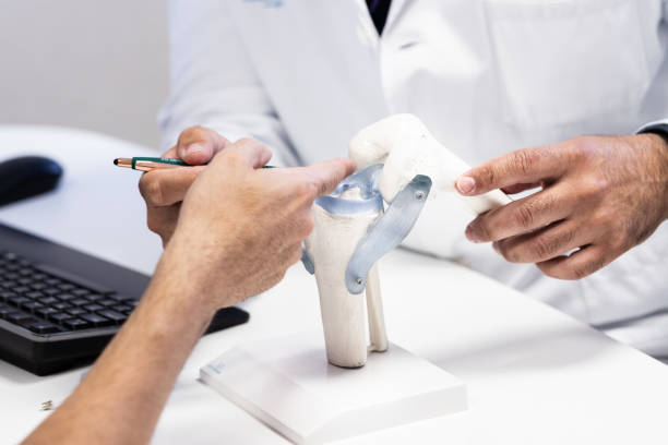 istock Doctor Explaining Knee Ligaments to Patient 2180710179