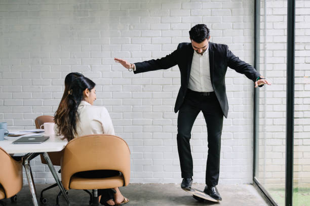 Asian Indian business people doing balance exercise while meeting in office.