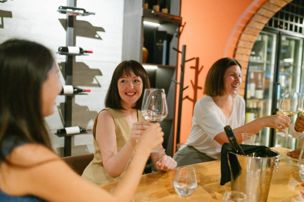 istock Female friends tasting wine in a winery 2180711243
