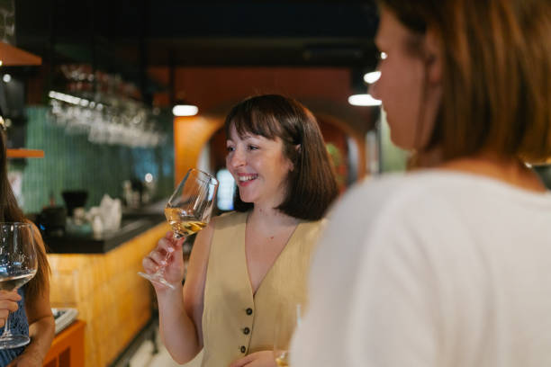 istock Female friends tasting wine in a winery 2180715542