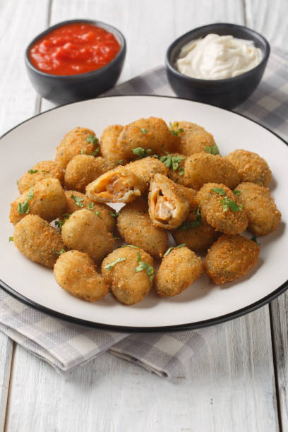 istock Appetizer Fried breaded mussels served with mayonnaise and ketchup close-up in a plate. Vertical 2180717687