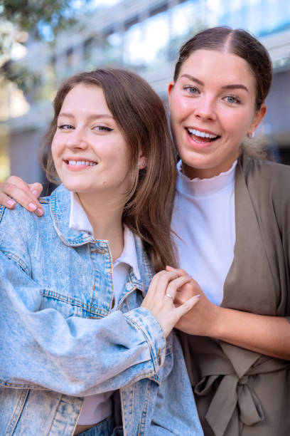istock Two Smiling Young Women Posing Outdoors on a Sunny Day.Vertical 2180719076