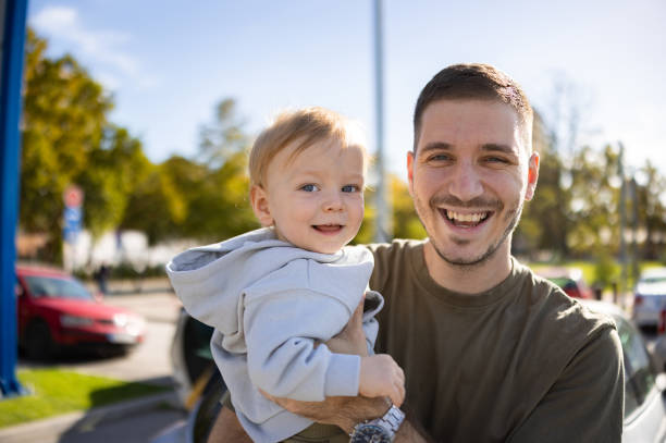 istock Smiling baby boy in fathers  arms 2180719525