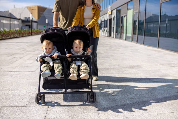 istock Unrecognizable couple with twins babies in stroller on the street 2180720955