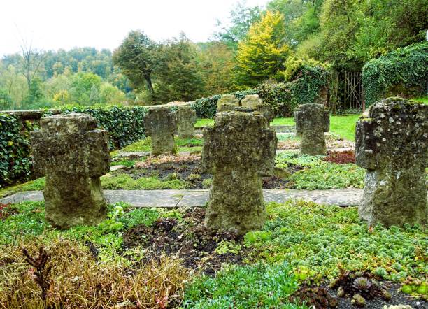 istock Ancient stone crosses in a lush cemetery 2180723854