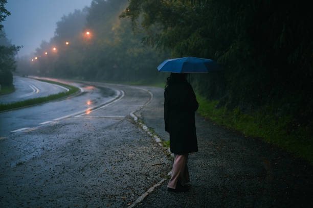 istock Woman walking on wet empty street. 2180727556