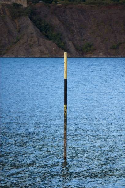A beautiful shot of a calm seascape with a broken pillar sticking out of the water on the horizon background.\nD.H