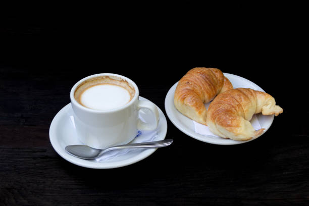 istock cup of coffee with milk and croissants 2180730262