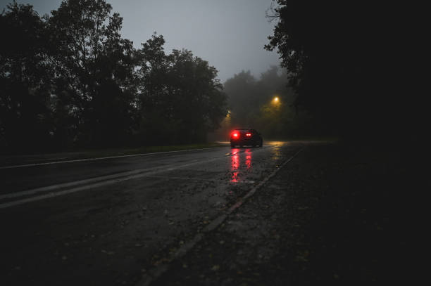 istock landscape with a moving car at night. 2180730759