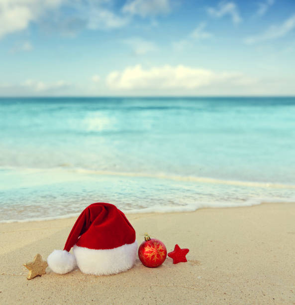 istock Christmas background with red Santa hat and decorations on Caribbean Beach. 2180731128