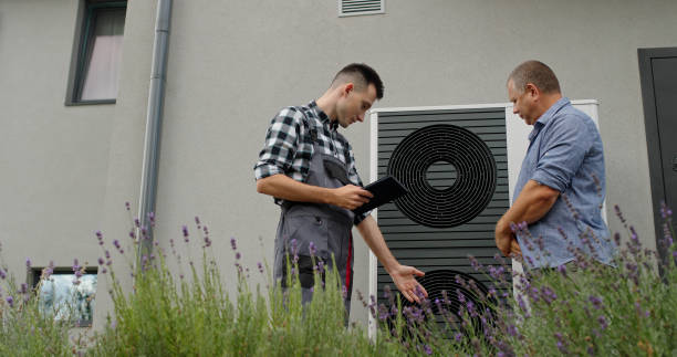 istock A technician consults with a homeowner about a heat pump, using a tablet for demonstration beside the unit. 2180737139