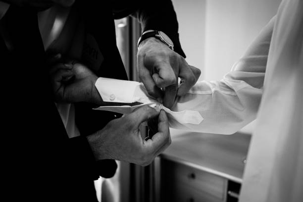 istock Friend helps groom get dressed for the wedding. 2180737284