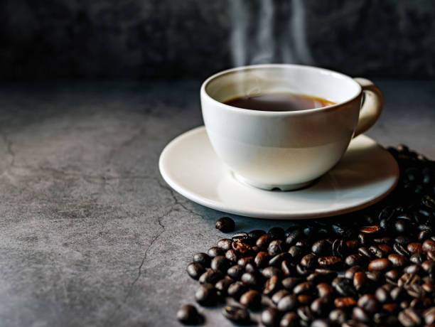 istock Americano coffee cup and roasted coffee beans falling in a burlap sackon gray background, Black coffee cup aromatic 2180739774