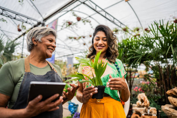istock Saleswoman serving customer using digital tablet at a garden center 2180741496