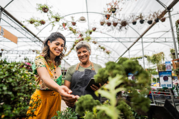 Saleswoman serving customer using digital tablet at a garden center
