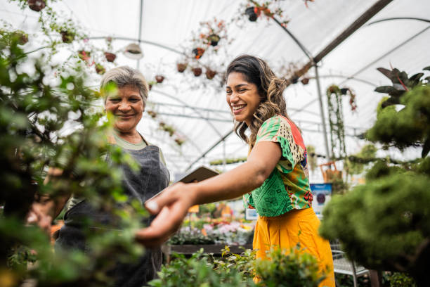 istock Saleswoman serving customer using digital tablet at a garden center 2180741615