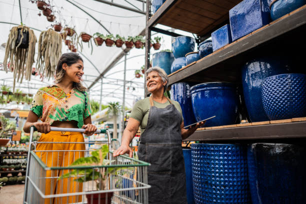 istock Saleswoman serving customer using digital tablet at a garden center 2180741638