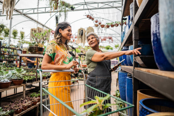 istock Saleswoman serving customer using digital tablet at a garden center 2180741660