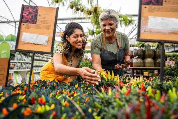istock Saleswoman serving customer using digital tablet at a garden center 2180741721