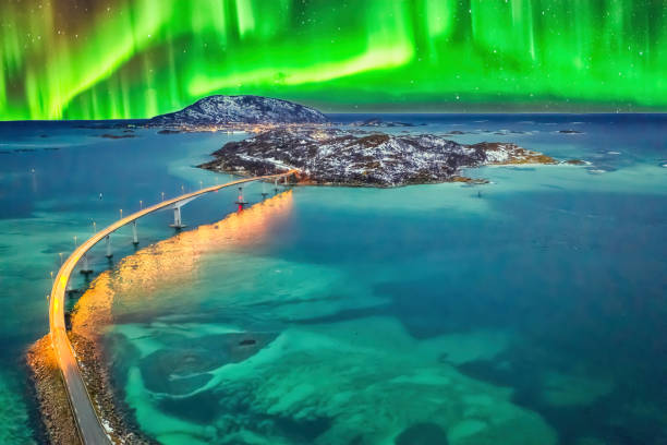 Northern lights aurora borealis between clouds in Sommaroy, Tromso, Norway