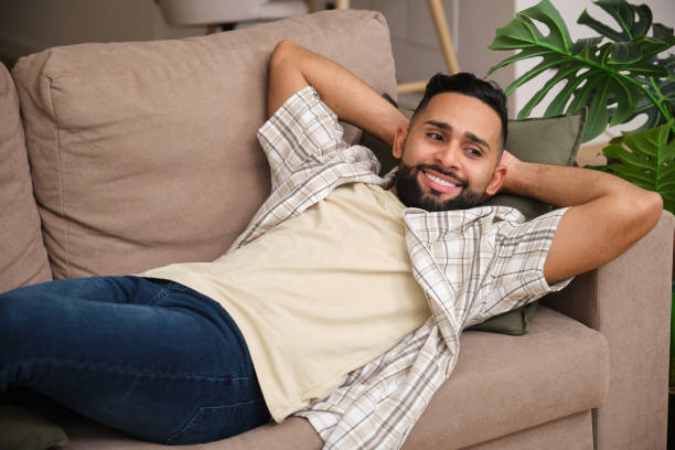 istock Handsome bearded man relaxing on comfortable sofa at home 2180750515