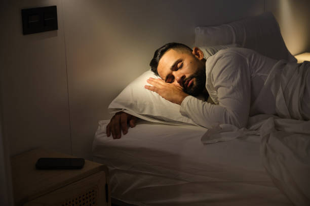 istock Young man sleeping peacefully in bed at night 2180750580