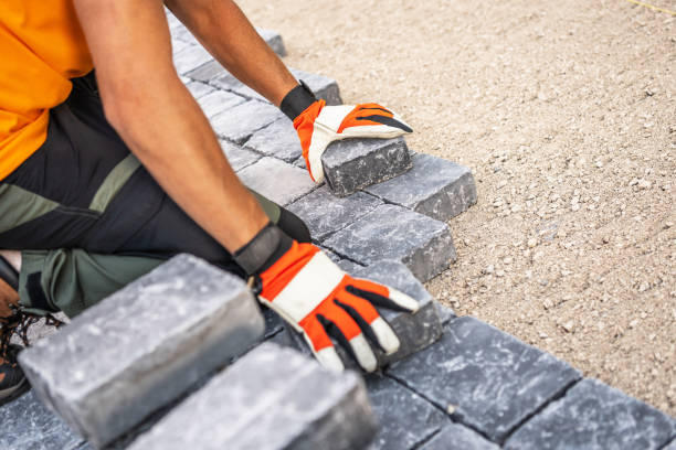 istock Construction Worker Laying Pavement Stones on a Gravel Surface During Daytime 2180756631
