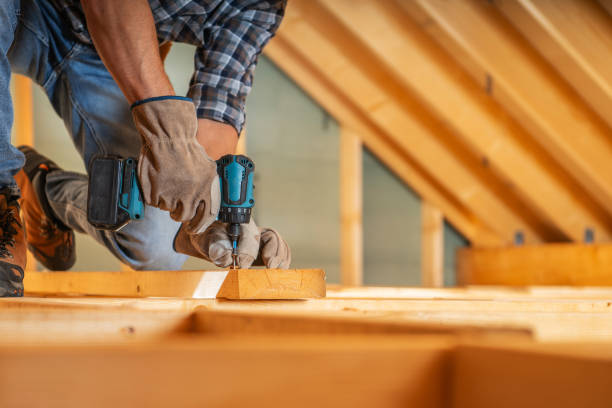 A Carpenter Uses a Power Drill to Secure Beams in a Daylight Attic Renovation