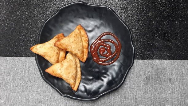 istock Fried samosas with ketchup on a black plate 2180761514