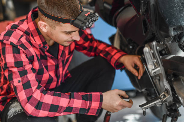 istock Motivated Young Worker Learning Mechanic Craft Working on Motorbike at His Father's Workshop 2180762396