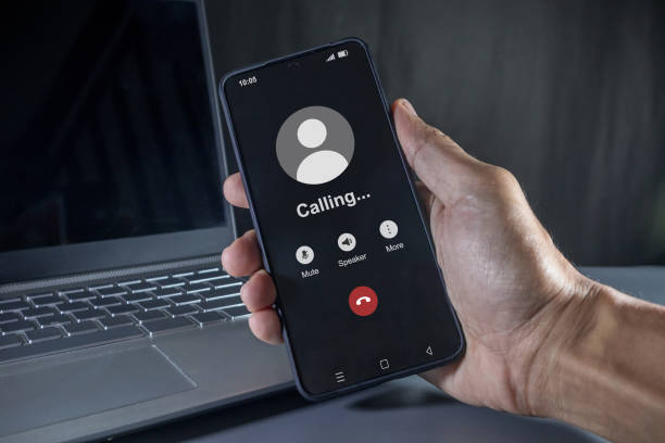 istock Hand holding a mobile phone with outgoing call screen. Call someone with a voice call. 2180762474