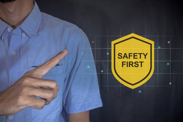 Man points to the Safety First symbol on the virtual screen beside him. Safety first concept.