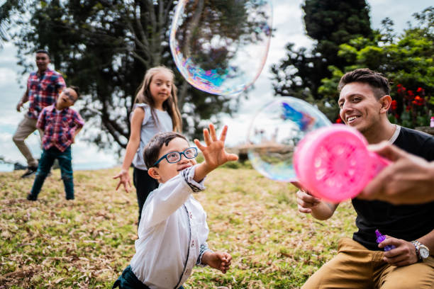 Kids with down syndrome playing soap bubbles outdoors