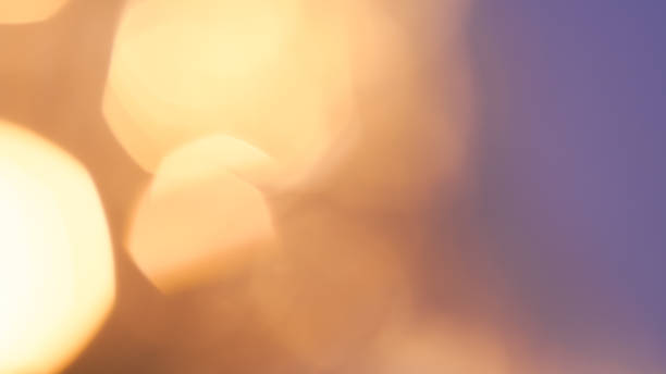 istock Soft golden bokeh lights with blurred circles on a warm gradient background 2180777438