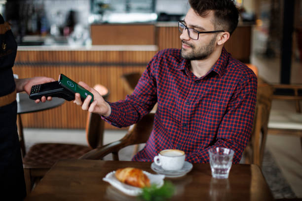 istock Cafe customer making a contactless payment with his smartphone 2180779230