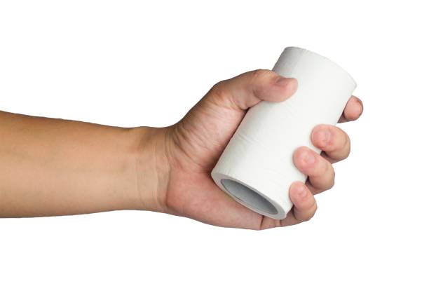 A hand holding a roll of toilet paper