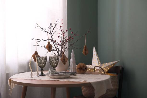 istock A stylishly designed holiday christmas table setting. Vase with dried branches, glasses, empty plates, decorative burning star in living room. Winter consept. 2180781603
