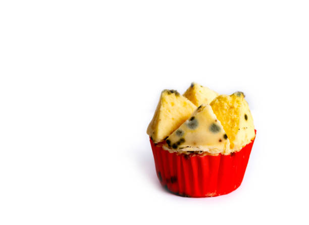 Isolated spoiled Thai dessert, 'Pui Fai', is covered with black and colored mold, making it unsafe to eat on white background.