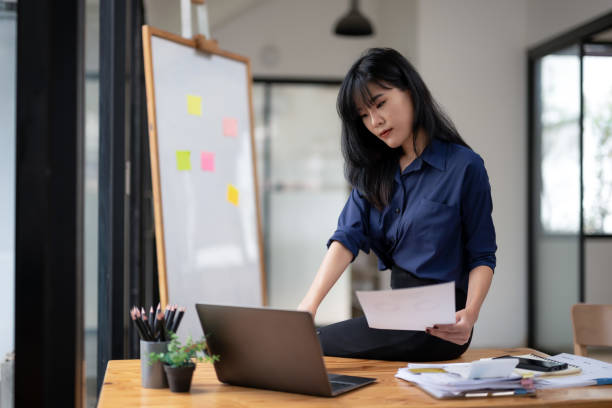 istock Young businesswoman checking documents in work area. 2180785239