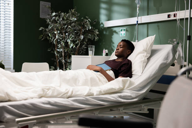 istock Young African patient with book while lying in the hospital bed 2180790290