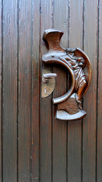 istock Intricately Carved Wooden Door Handle Featuring a Bat Design in a Rustic Setting 2180791443