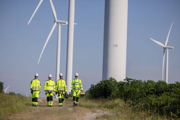 istock Engineers inspect the large wing turbine farm 2180791610