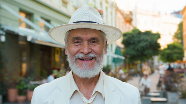 istock Smiling happy laughing old senior guy elderly mature grey-haired Caucasian elegant businessman male man tourist traveler looking at camera positive expression outside city street holidays retirement 2180795862